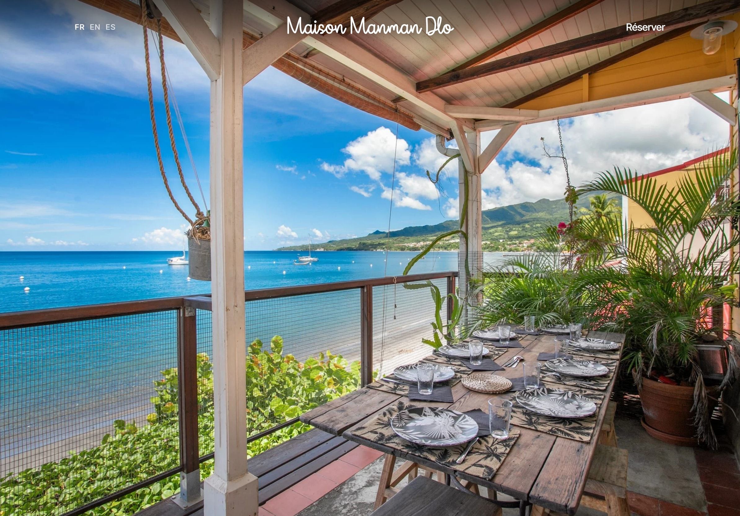 Page d’accueil du site de la Maison Manman Dlo, une terrasse en bord de mer face à la baie